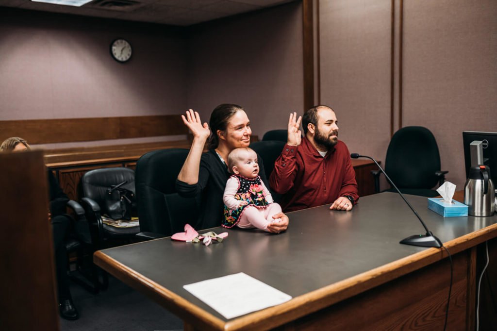man and woman hold their hands up for court oath