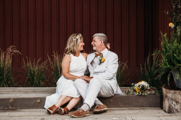 bride and groom sit on concrete step