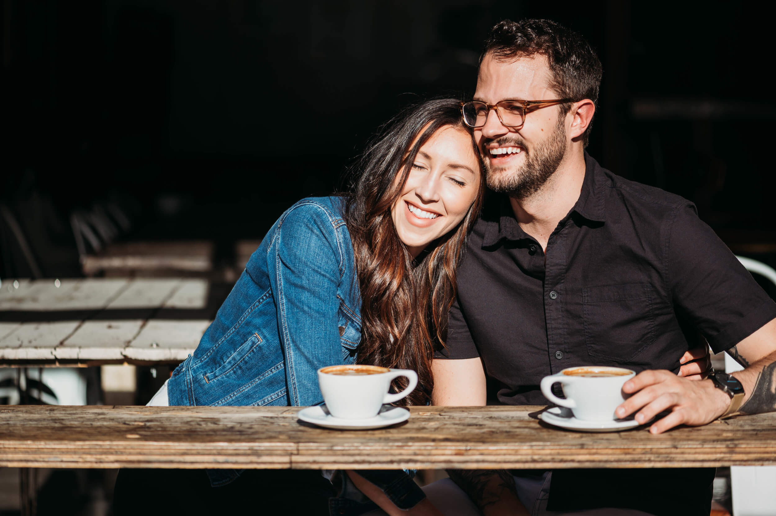 woman leaning on man's shoulder at coffee bar